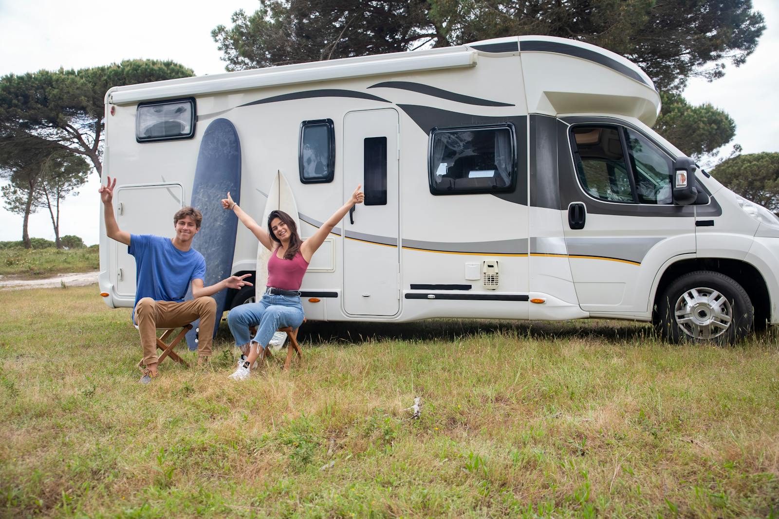 mobile home, Happy couple relaxing by camper van in sunny campsite, Portugal.